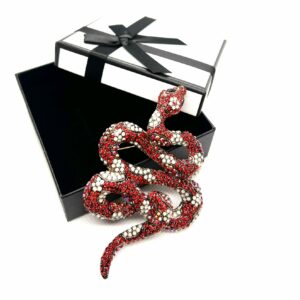 La spilla a forma di serpente è un gioiello elegante e sofisticato, arricchita da strass neri e bianchi che ne esaltano il design sinuoso e affascinante. La combinazione di cristalli scuri e luminosi crea un contrasto elegante, che cattura la luce e aggiunge un tocco di glamour al look. Il serpente, simbolo di trasformazione e mistero, è realizzato con dettagli finemente lavorati, dando vita a un accessorio che unisce stile e simbolismo. Perfetta per chi cerca un tocco di classe e originalità, questa spilla è ideale per completare outfit da sera o aggiungere un accento di lusso anche a look più quotidiani.